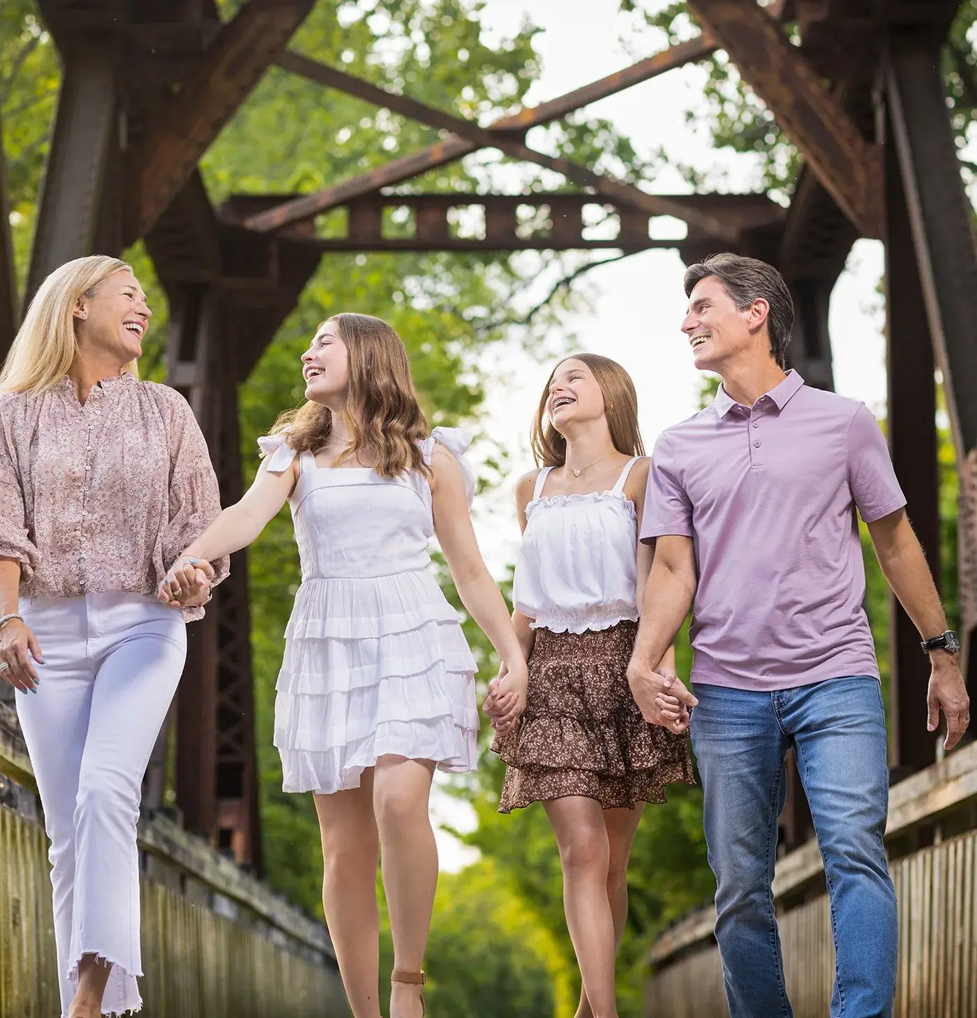 Family walking the old covered bridge in fall