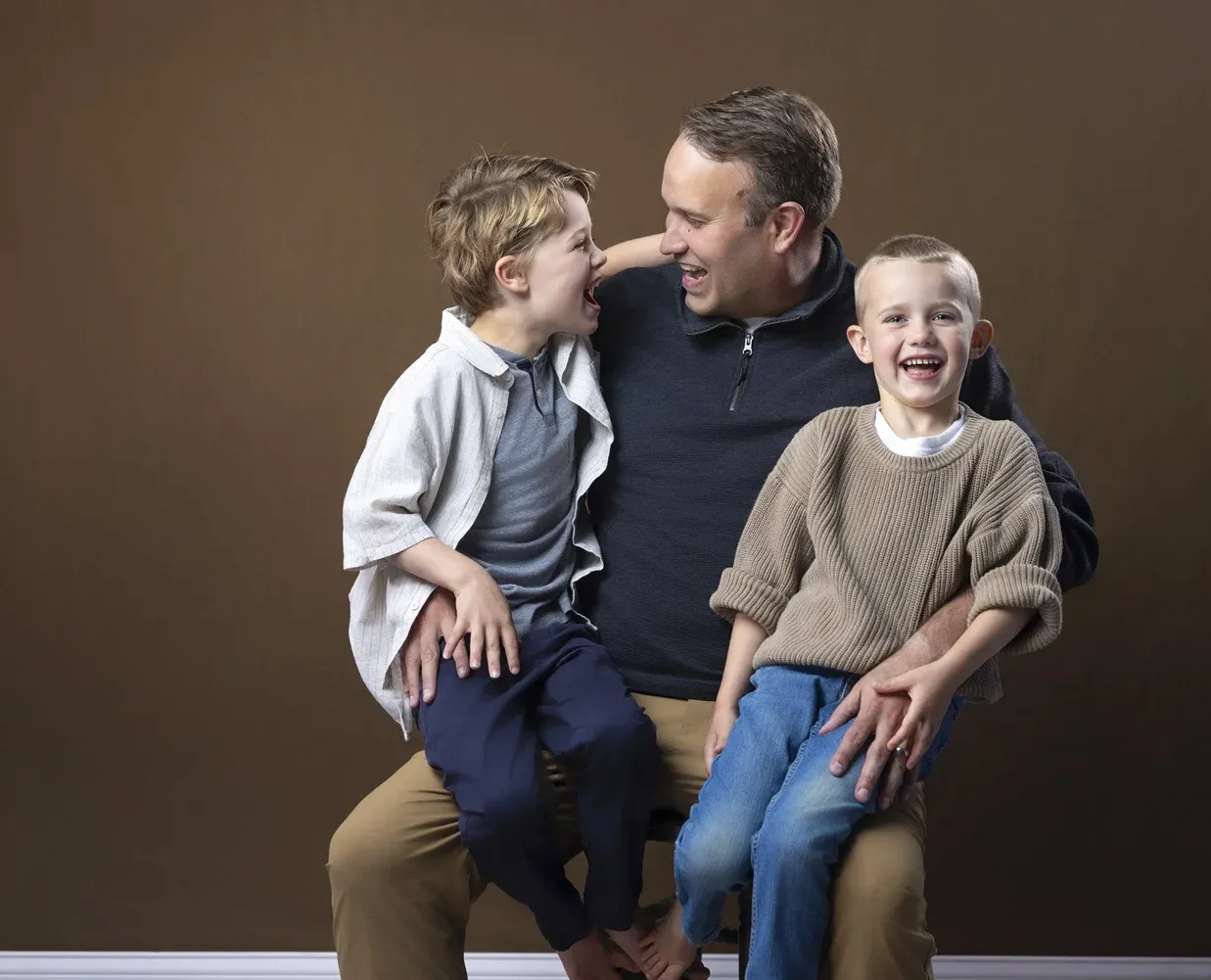 Dad laughing with his two boys in the studio