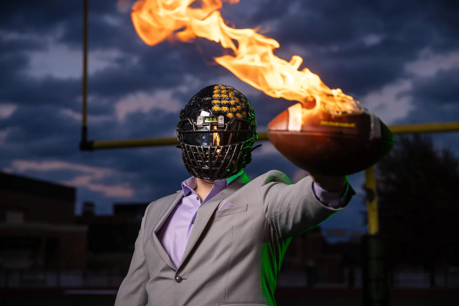 Senior portrait in a suit with flaming football helmet